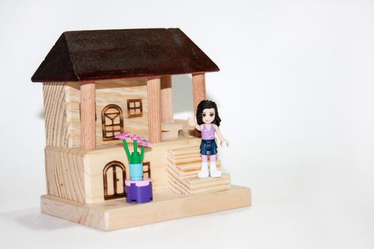 Wooden house and plastic toys on the white background.