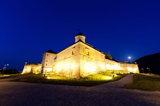 Old fortress "Cetatuia" illuminated at night, Brasov, Romania