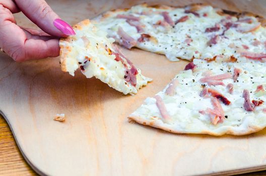 The Tarte is called German Pizza has a very thin crust. But is probably more from the French territory.
In the Alsace region of France, he is often served as an appetizer.