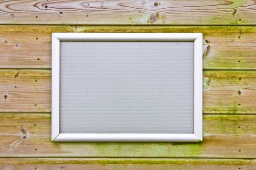 An empty picture frame on wooden background