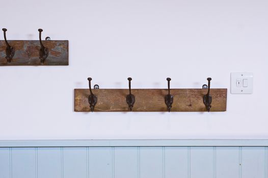 Antique coat hooks on a white wall