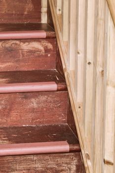 Close up of part of a wooden stair case with bannisters