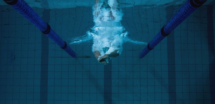 Fit swimmer training on his own in the swimming pool at the leisure centre