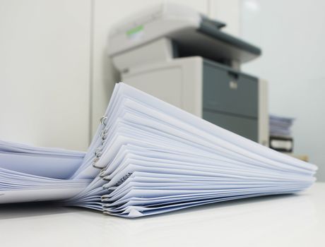 The document has been printed, be set and arranged as pile in front of the copier at office.                               