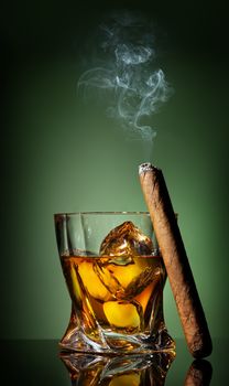 Whiskey and cigar on a green background