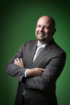 Image of a laughing businessman with a bald head and beard against a green background