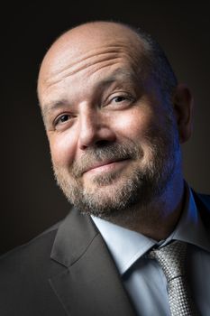 Bald headed businessman with beard pulls his eyebrow