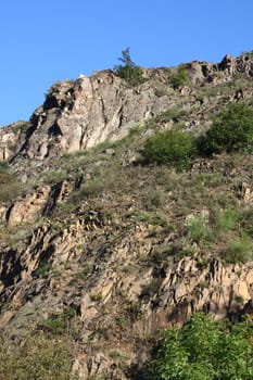 A landscape in the highlands, with rocks, trees and blue sky