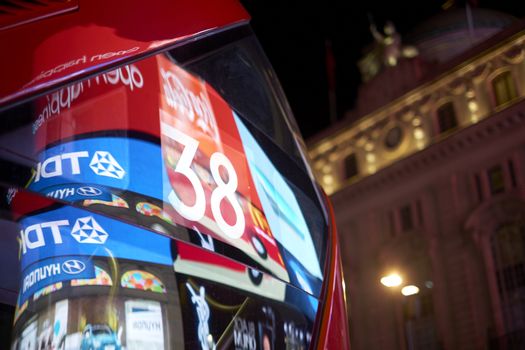 LONDON, UK - DECEMBER 19: Detail of London red bus line 38 reflecting lights of Piccadilly Circus at night. December 19, 2014 in London.