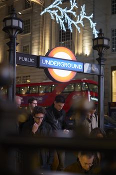 LONDON, UK - DECEMBER 19: Commuters entering Piccadilly Circus underground station at night. December 19, 2014 in London.