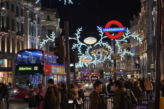 LONDON, UK - DECEMBER 20: Nighttime shot of busy Oxford Circus underground entrance with Christmas lights in Regent Street. December 20, 2014 in London.