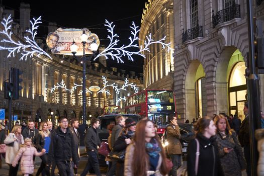 LONDON, UK - DECEMBER 19: Very busy Regent street at night, with Chrismas decoration and red double decker buses in the background. December 19, 2014 in London.