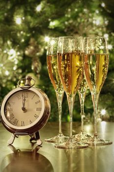 Champagne glasses, clock with lights at midnight 