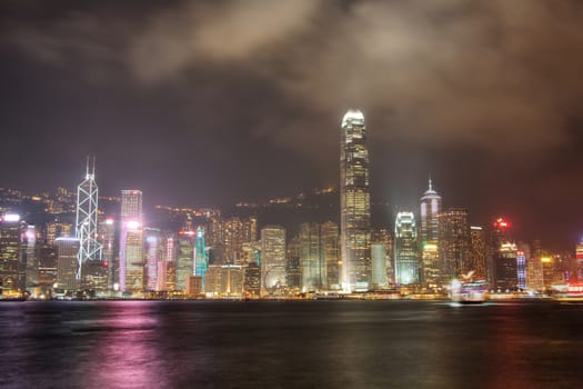 Skyline of Hong Kong  at Night with the colours reflecting off the harbour.