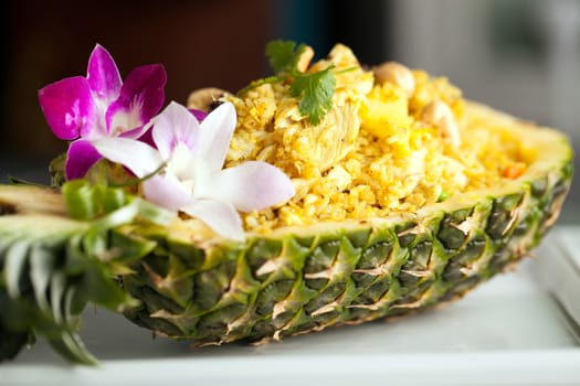 Freshly prepared pineapple fried rice served inside of a pineapple carved like a bowl.