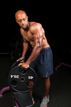 Toned and ripped lean muscle fitness man lifting plate weights.