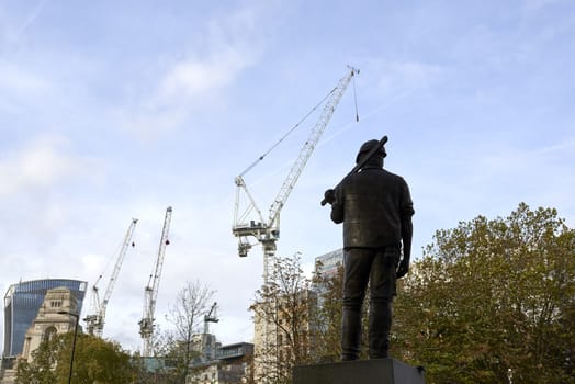 LONDON, UK - NOVEMBER 08: The Building Worker statue, near the Tower of London. NOVEMBER 08, 2014 in London. The statue commemorates construction workers who have lost their lives at work. 