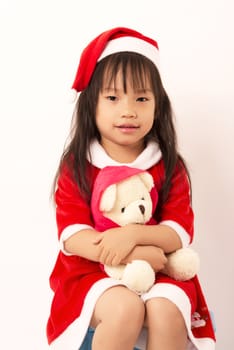 Asian little girl in red santa hat on white background