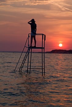 Photo shows a sunset above the beach and sea.