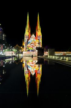 SYDNEY, AUSTRALIA - DECEMBER 23, 2014; St Mary's Cathedral Sydney CBD Madonna and Child display on building facade at Christmas time with reflections in pond water.