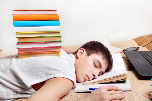 Tired Teenager sleep on the Sofa with the Books