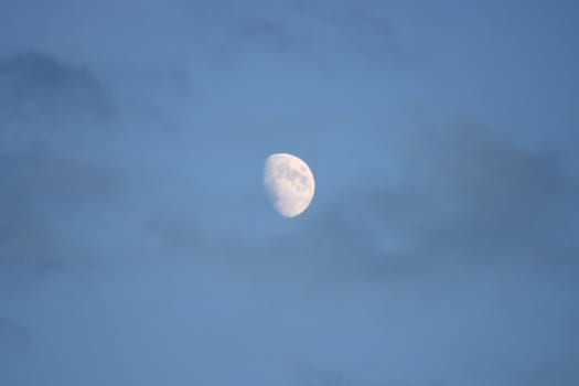 The moon with blue sky and dark clouds