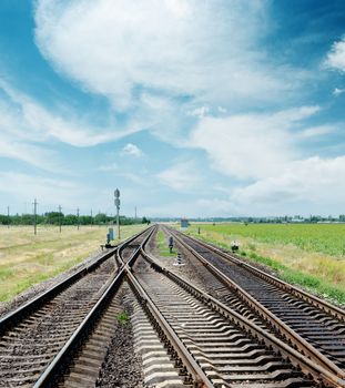 crossing of railroad to horizon under cloudy sky