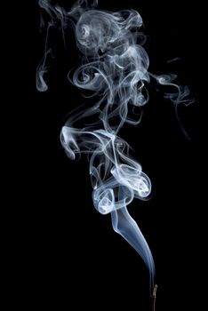 delicate smoke plume from a burning incense stick