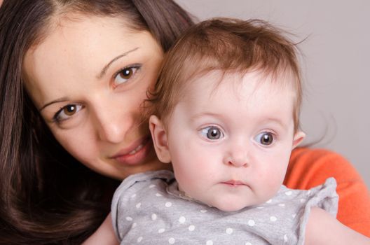 Portrait of mother and baby at the hands of six mothers