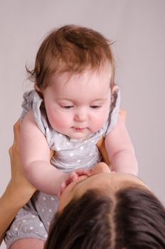 Portrait of mother and baby at the hands of six mothers