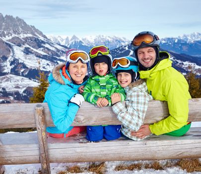 Skiers, sun and fun - Family with two kids enjoying winter vacations.