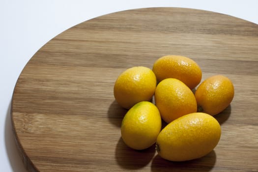 Fresh fruit kumquat on the kitchen wooden board.