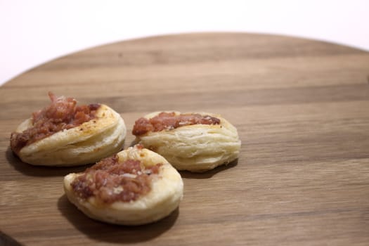 Mini pizza from bakery on the wooden board.