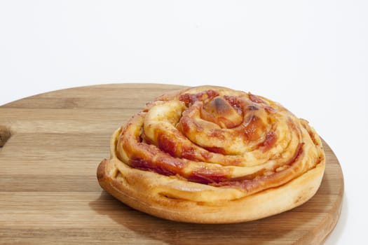 Fresh roll pastries from the bakery on the kitchen wooden board and white background.