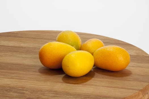 Fresh fruit kumquat on the wooden board.