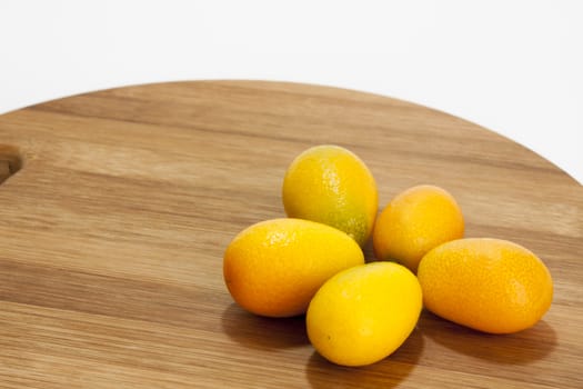 Fresh fruit kumquat on the wooden board.