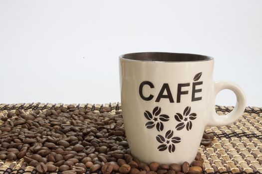 Cup of coffe on the bamboo background and coffee beans.