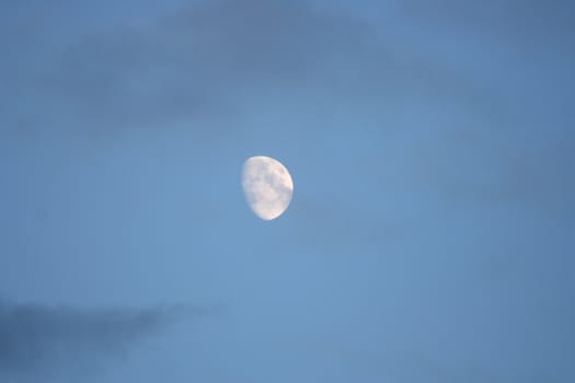 The moon with blue sky and dark clouds