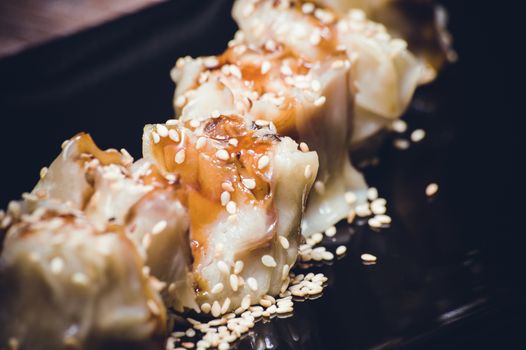 fried gyoza dumplings with sauce on black plate 