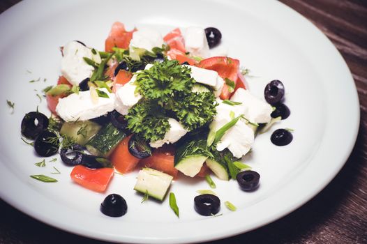 vegetarian greek salad served on white plate