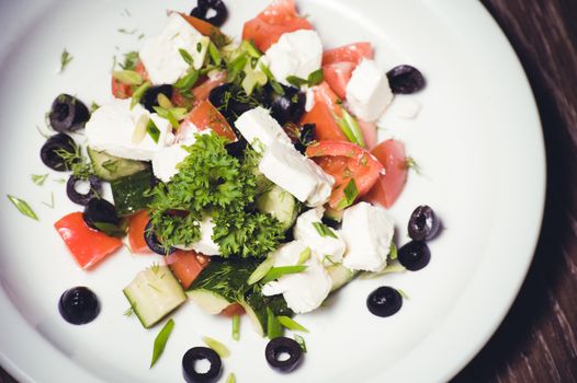 vegetarian greek salad served on white plate