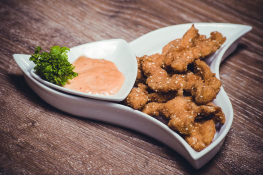 deep fried chiken breast strips on white plate 