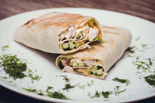 chicken and avocado fried wrap on white plate 