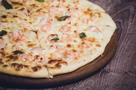 salmon and creamy sauce pizza on wooden board 