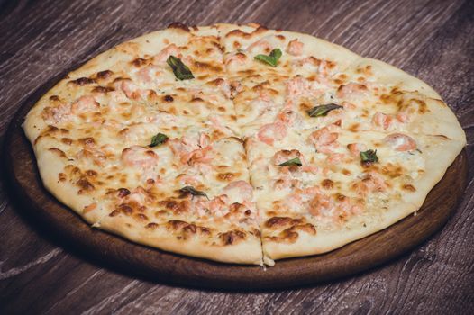 salmon and creamy sauce pizza on wooden board 