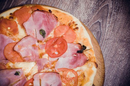 fresh tomato and ham pizza on wooden board 