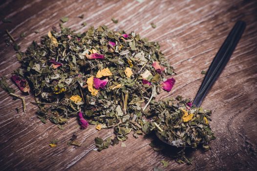 herbal tea with dried flowers on spoon 