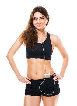 Beautiful slim woman listening to music while exercising on a white background