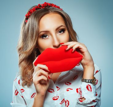 Pretty woman holding in hands big red lips, toy kiss-shaped, Valentine day concept