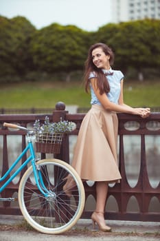 Young beautiful, elegantly dressed woman with bicycle. Beauty, fashion and lifestyle